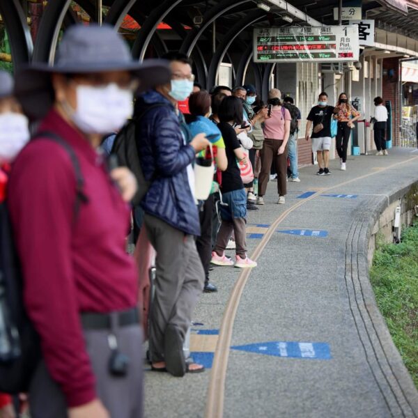 people lining up next to train tracks in Japan