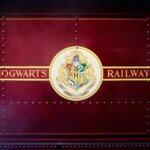 Side of a red train in Tokyo's Harry Potter theme that reads "Hogwarts Railways"